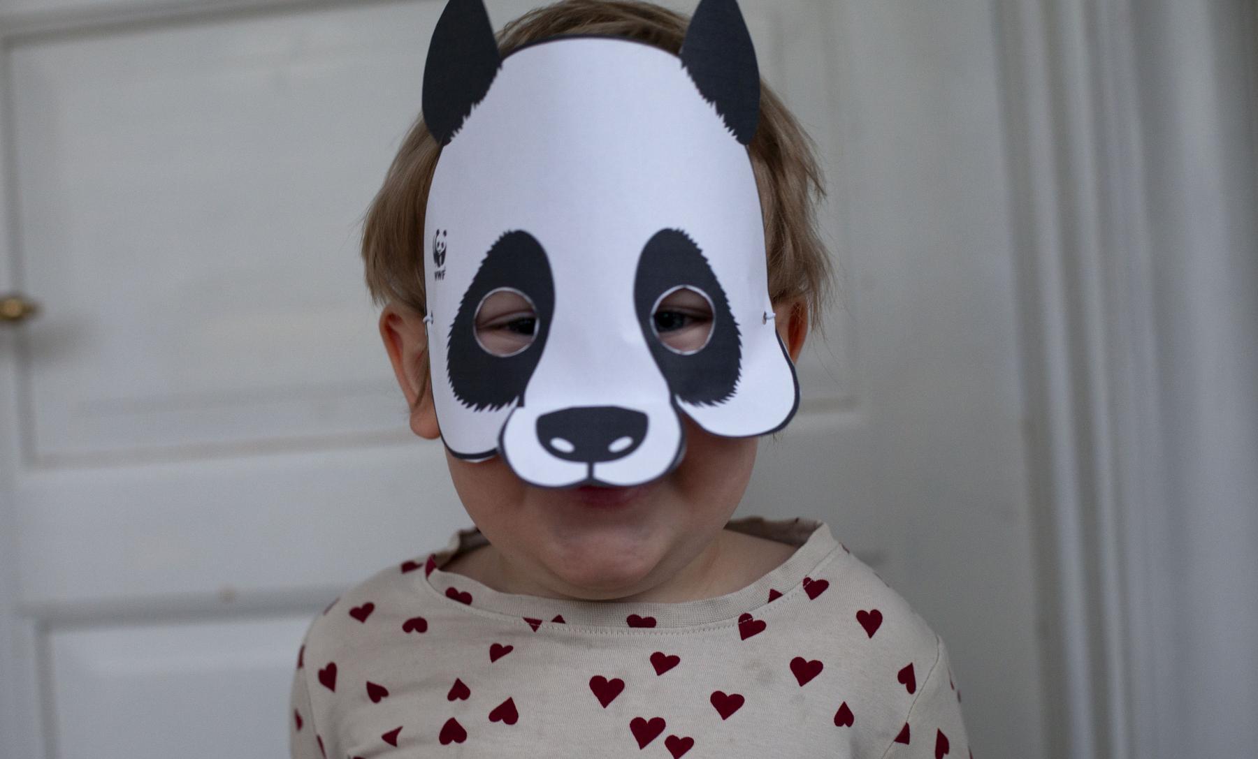 Barn med pandamask.
